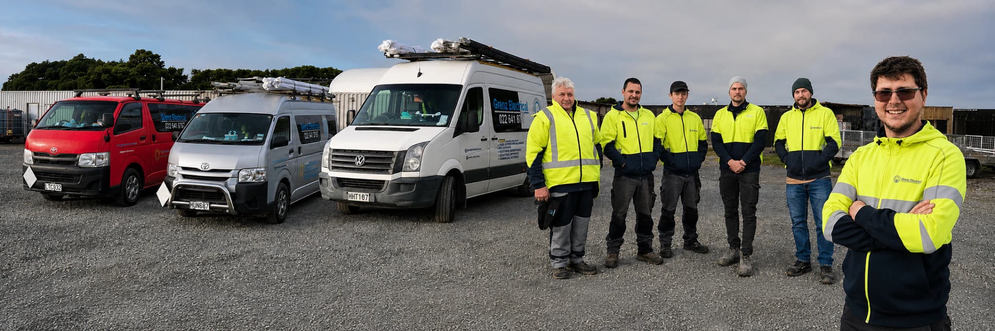 Grenz Electrical team standing beside company vehicles in Christchurch