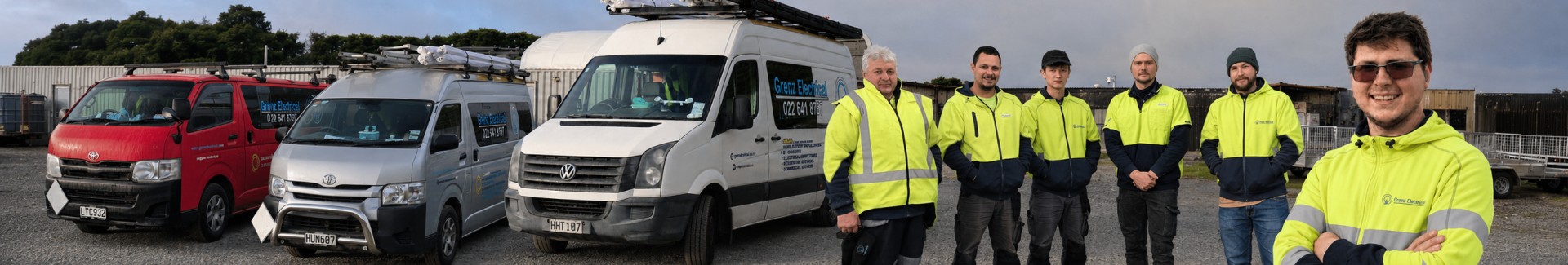 Grenz Electrical team standing beside company vehicles in Christchurch